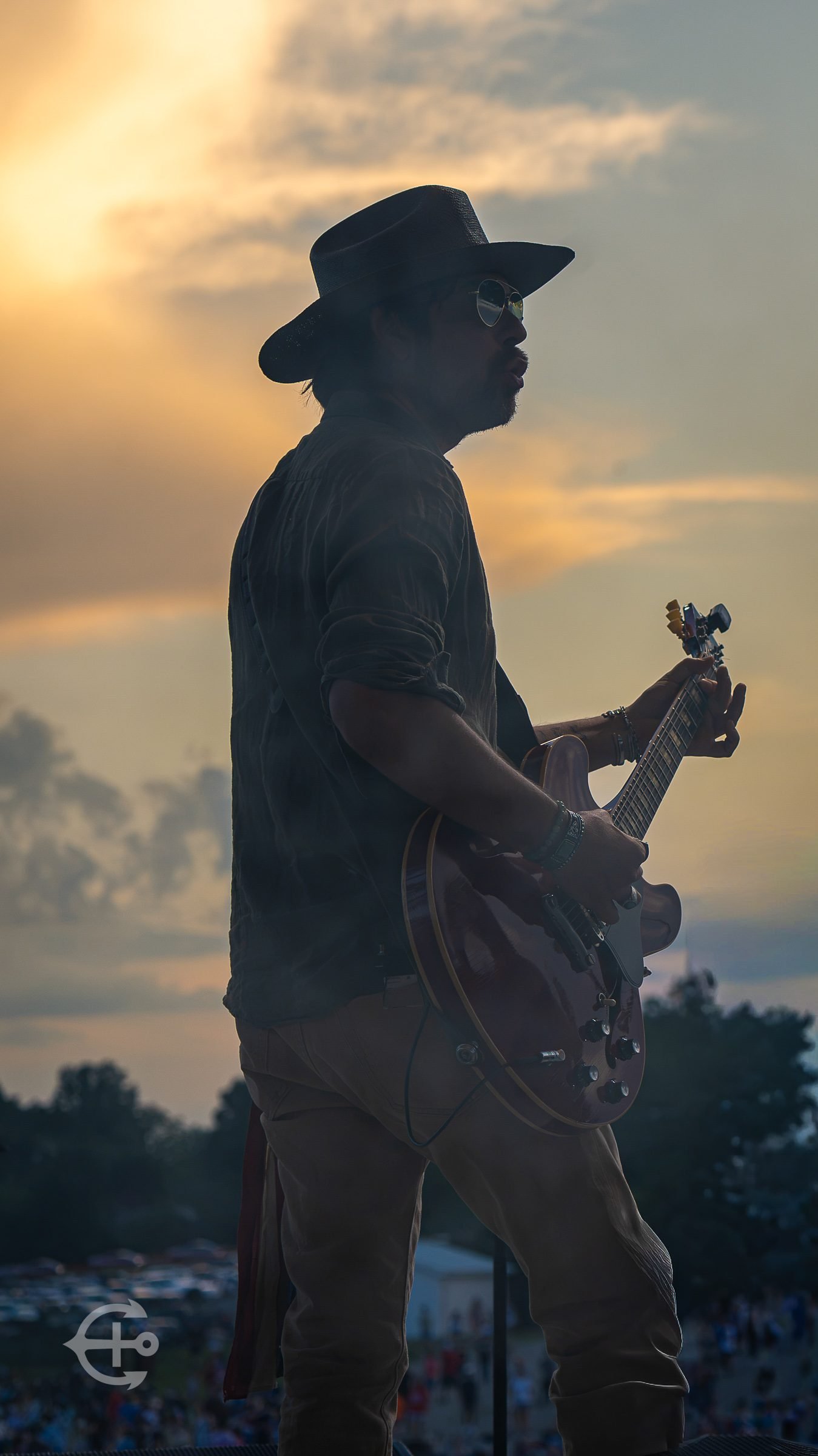 Guitarist silhouetted against a warm outdoor sunset