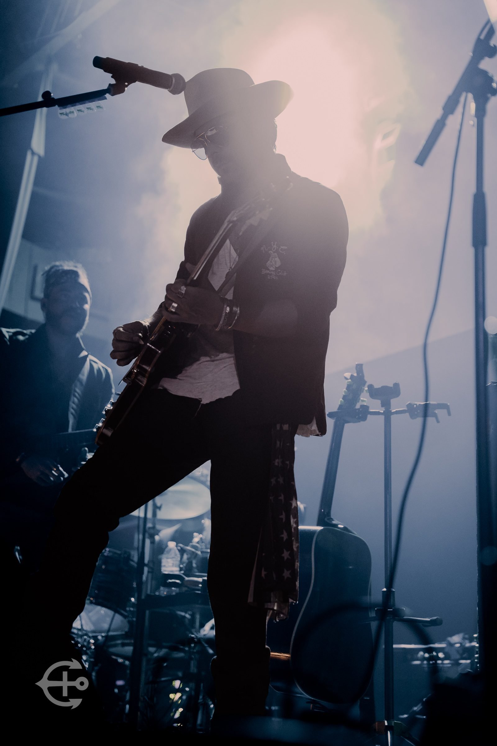 Guitarist silhouetted against bright concert lighting
