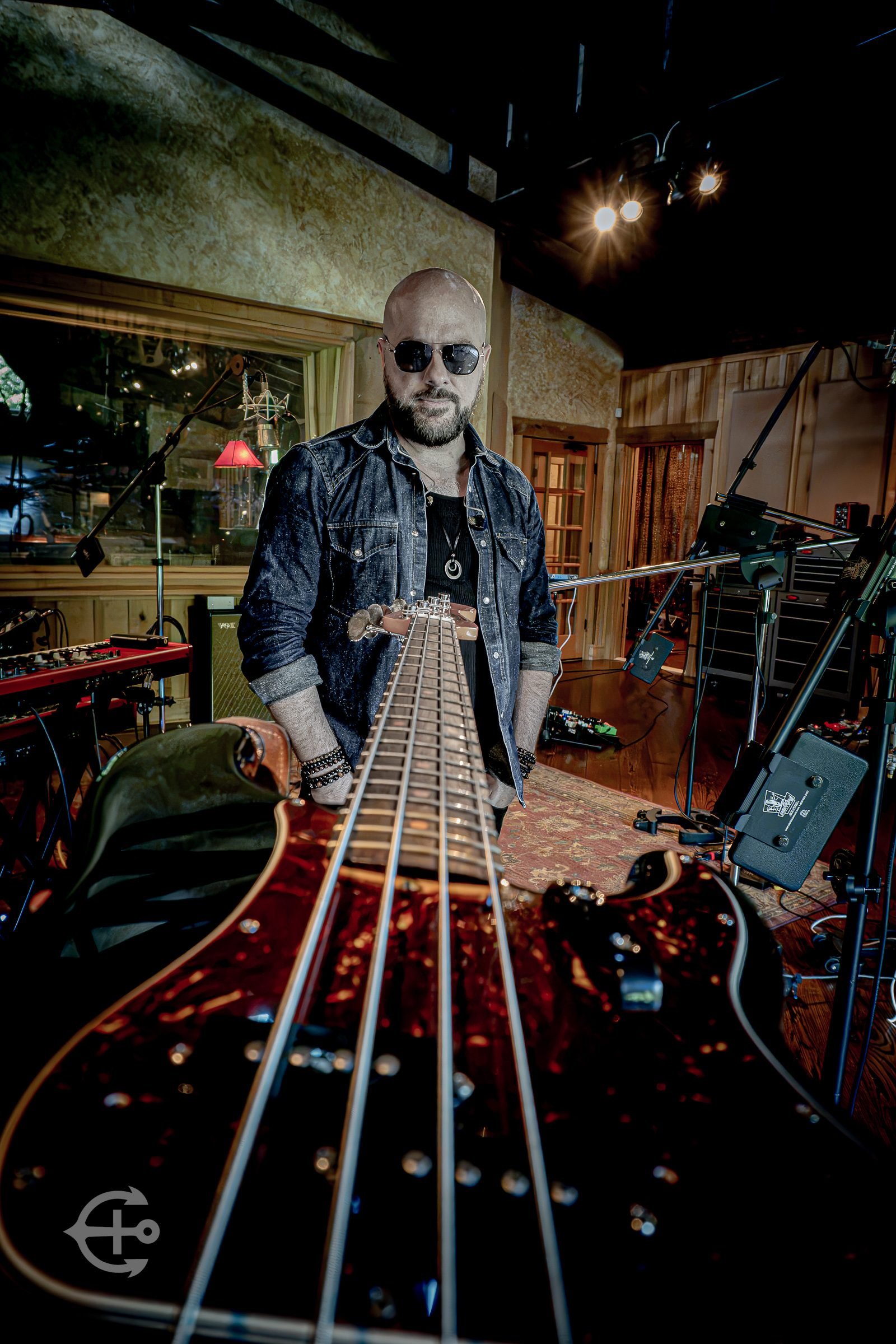 Bassist photographed along the neck of an electric bass