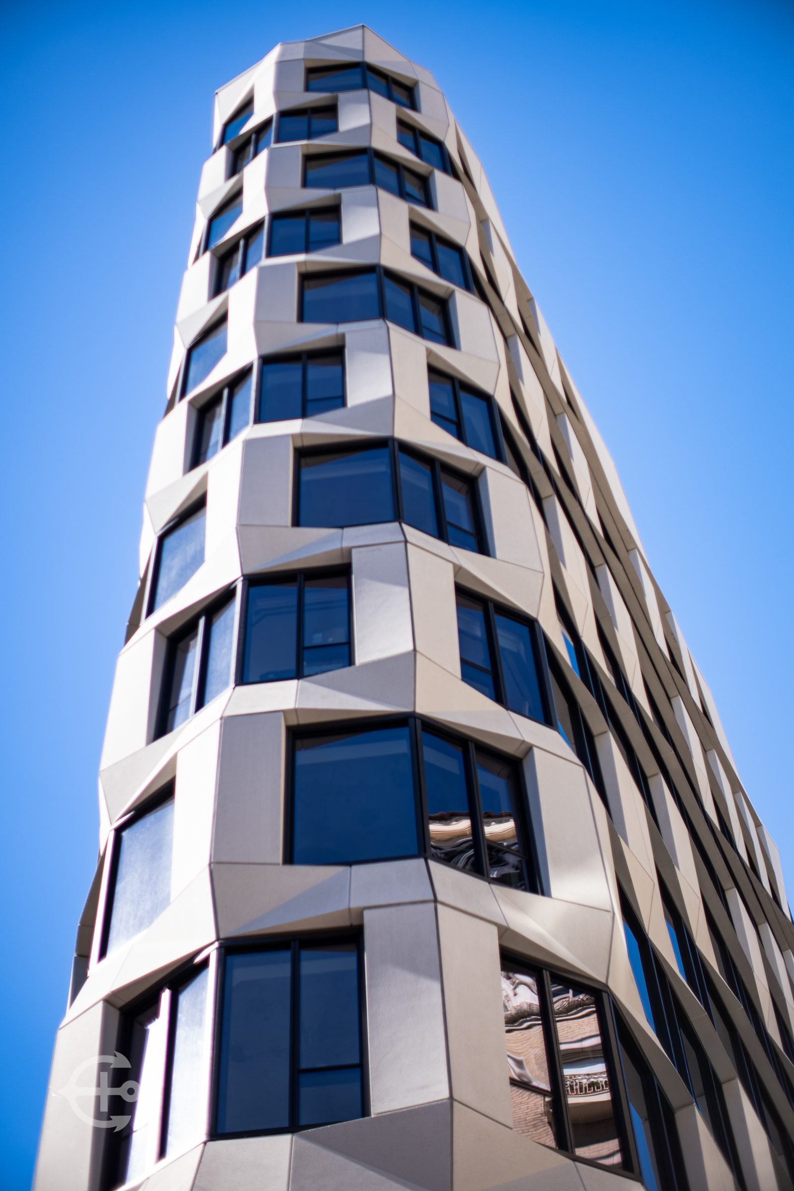 Modern curved building photographed against a blue sky