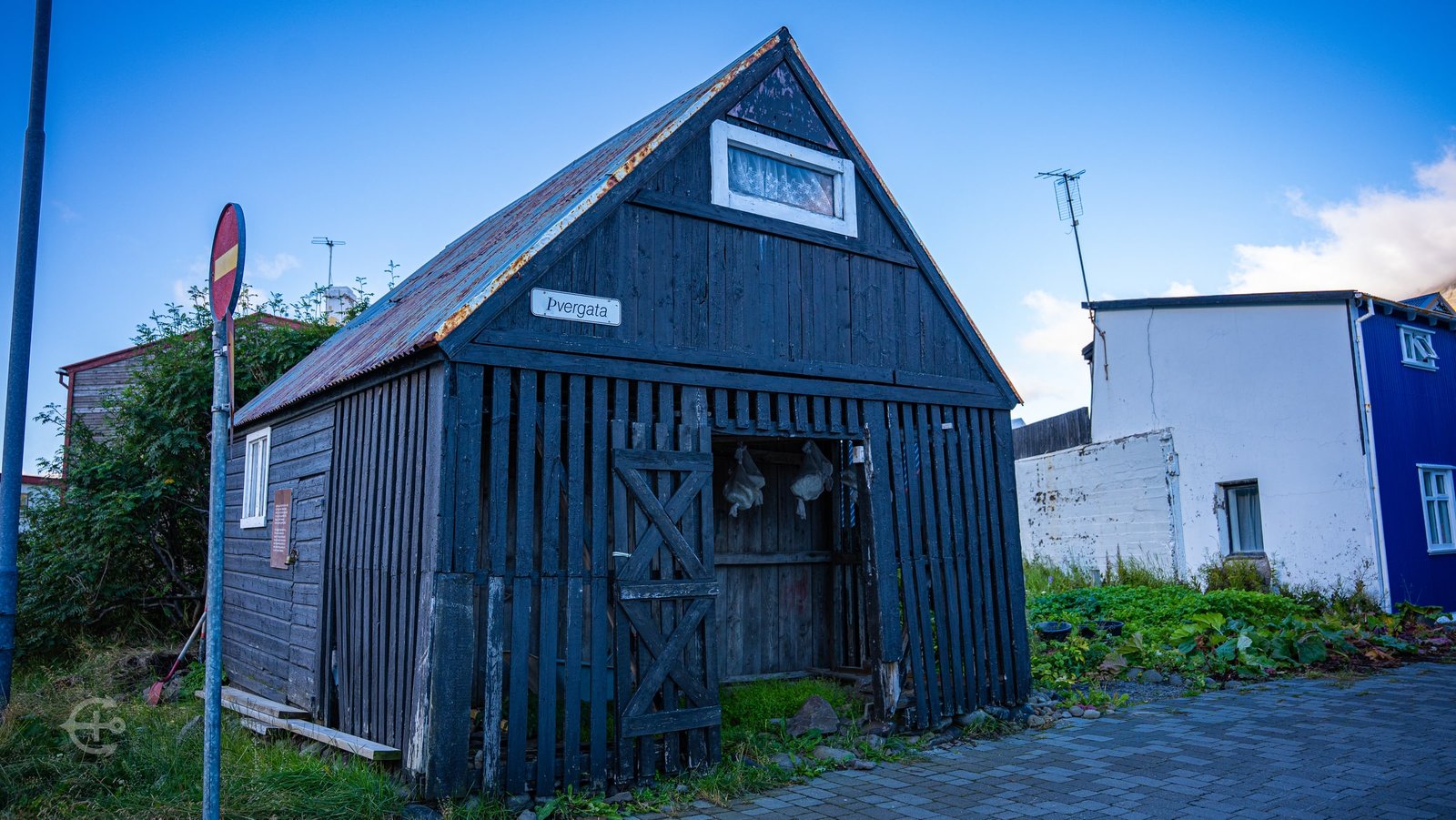 Weathered wooden building with a steep roof on a cobbled lane