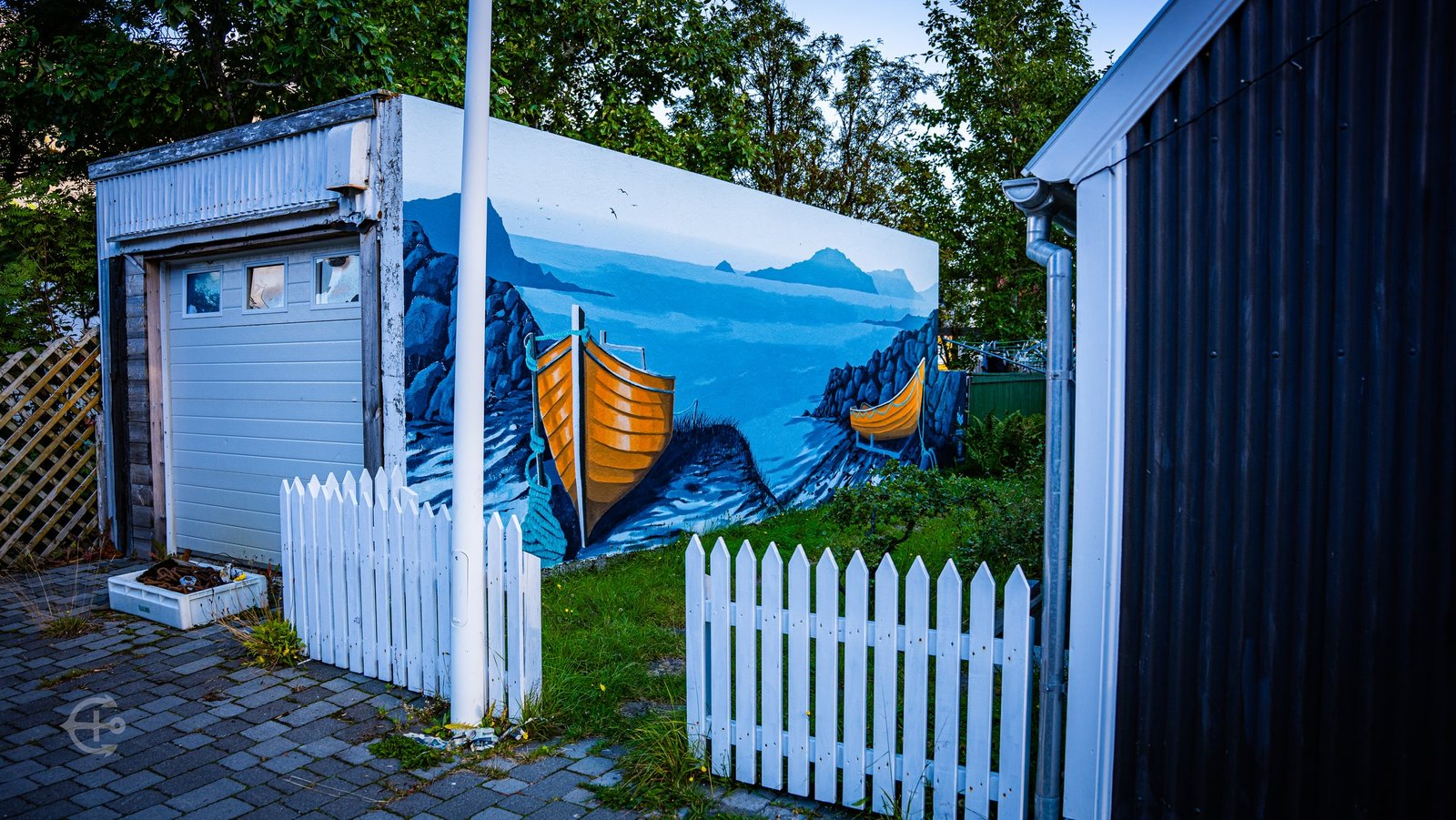Mural of yellow boats beside a white picket fence