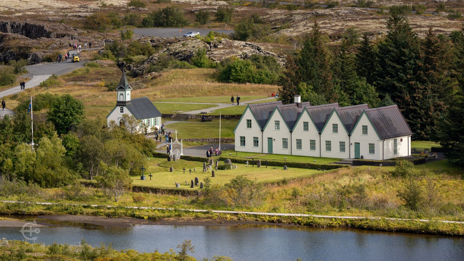 White church and gabled buildings beside a river