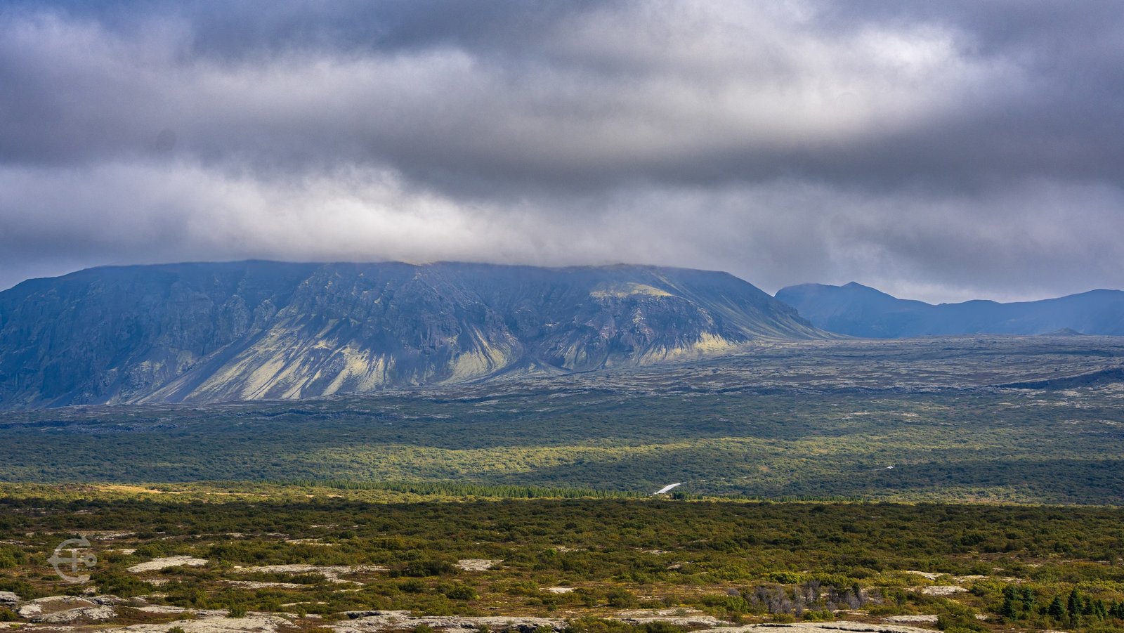 Low clouds over a mountain ridge and green valley